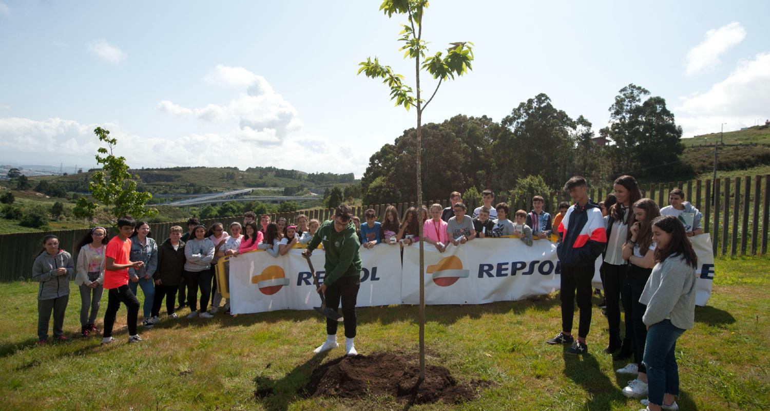 Alumnos de un instituto plantando un árbol