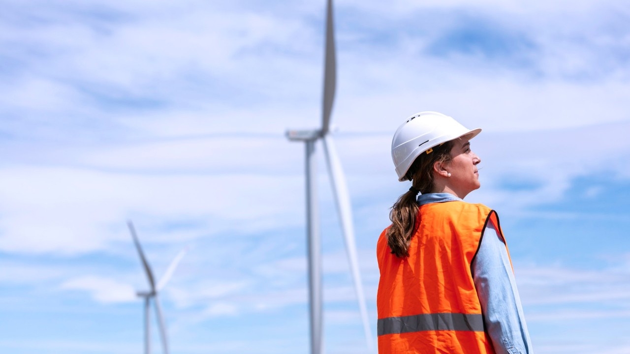 Empleada rodeada de aerogeneradores