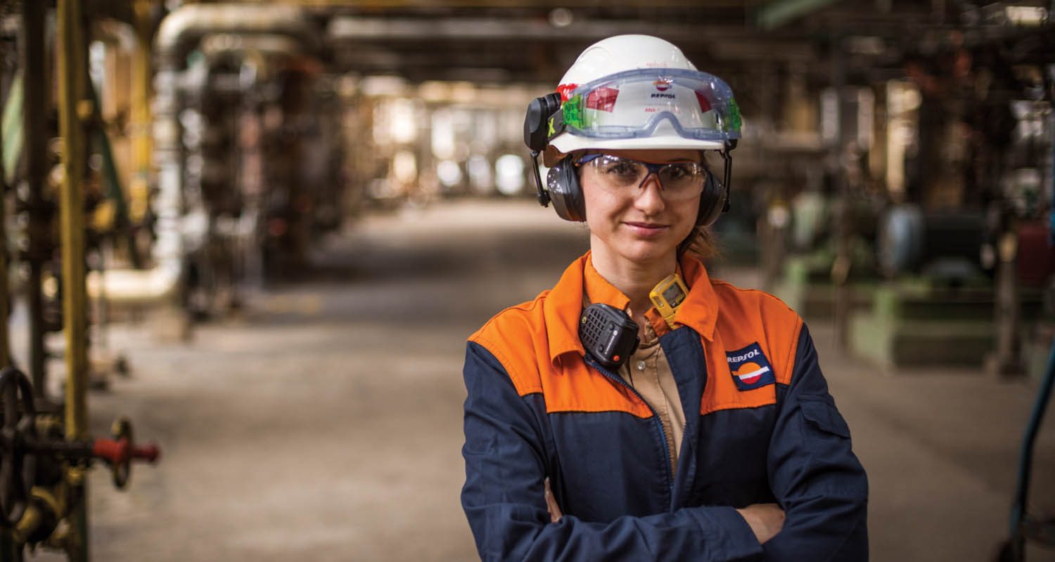 Empleada de Repsol con casco y gafas de seguridad en la refinería